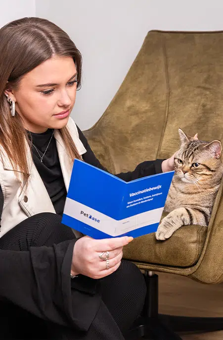 Baas leest vaccinatieboekje samen met kat waarin alle gegevens van de kat in staan